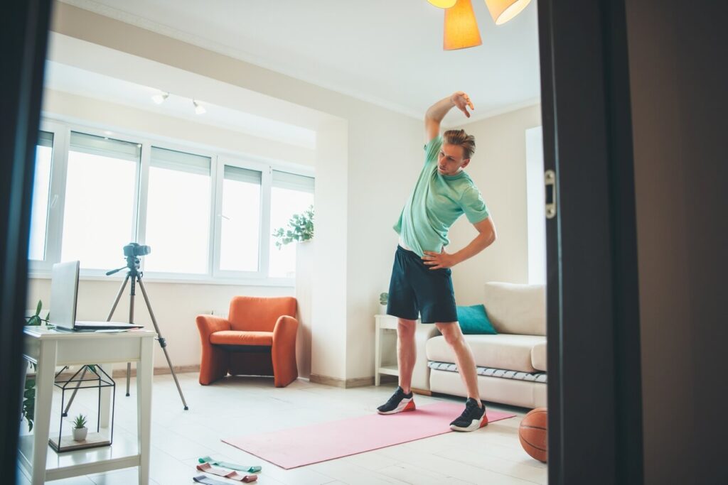 Full body workout w domu mężczyzna rozgrzewa się przed treningiem w domu