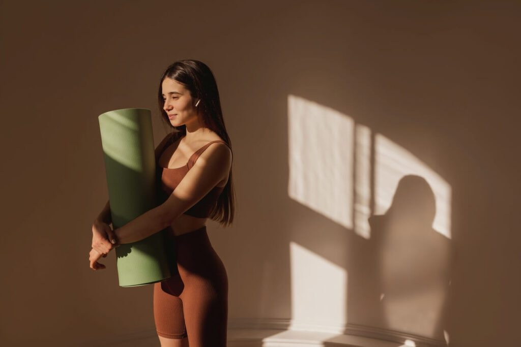 Pilates kobieta stoi z matą