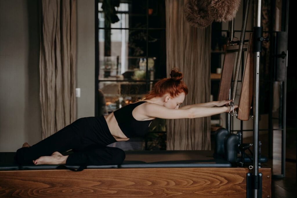 Pilates na reformerach wzmacnianie nóg na maszynie