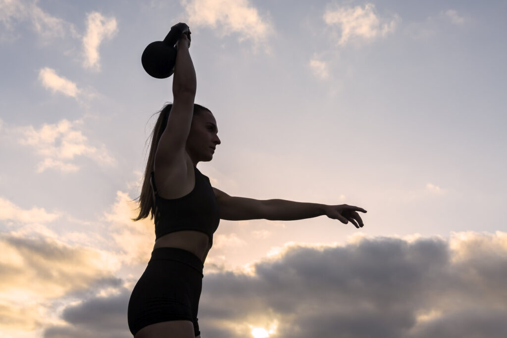 crossfit sylwetka kobieta ćwicząca z kettlą na zewnątrz